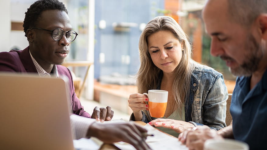 Real estate or financial advisor showing contract to couple at home during business meeting