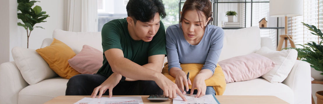 A young asian couple looking at documents.
